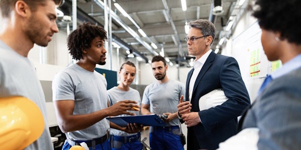 Team meeting with executive in warehouse